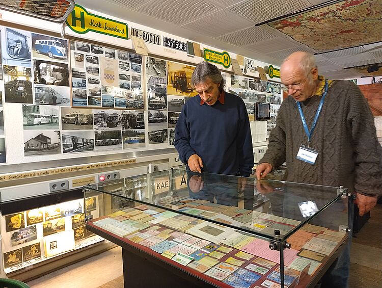 Museumsführer Udo Tauchert erklärt einem Besucher die Fahrkartensammlung
