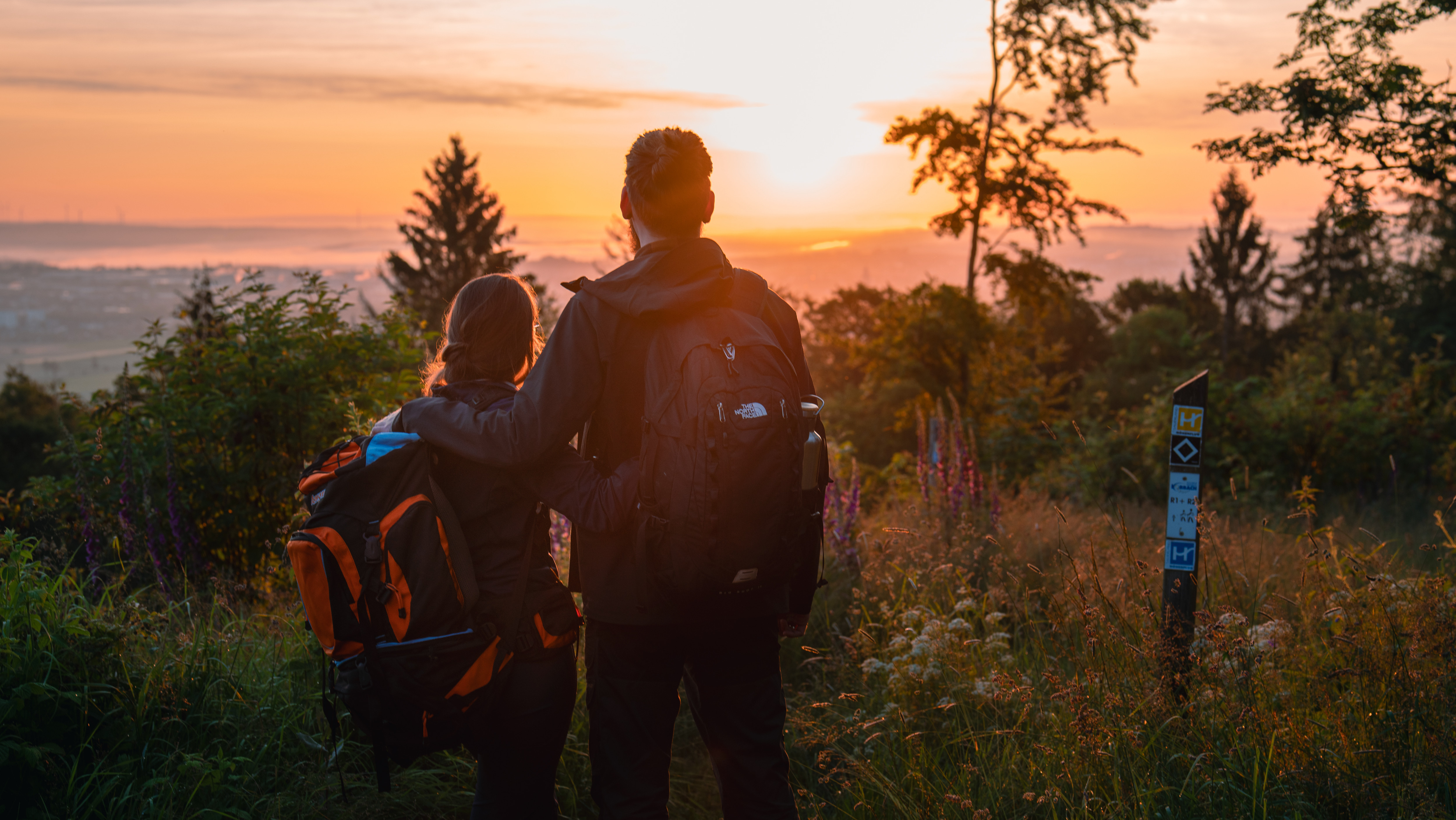 Wanderpaar vor Sonnenaufgang am Eisenberg in Korbach Wanderpaar vor Sonnenaufgang am Eisenberg in Korbach
